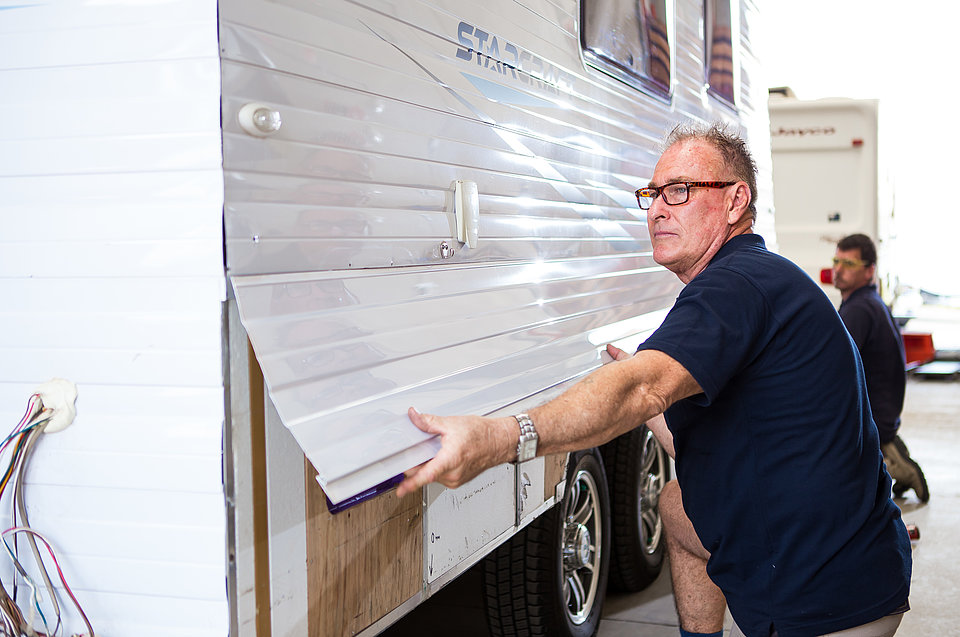 RV Service Centre technician resheeting a caravan