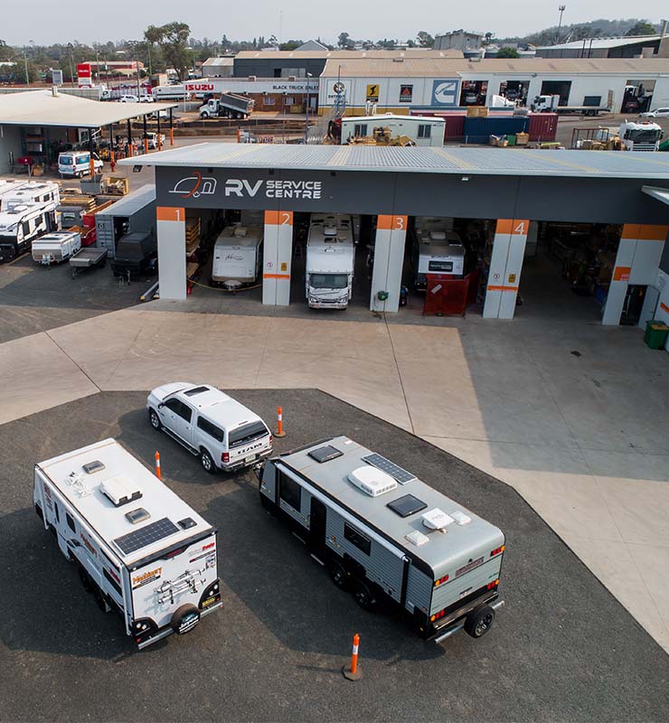 RV Service Centre exterior with caravans parked in front of building